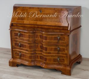 Reproduction of a baroque style chest of drawers with flap shaped in national walnut
