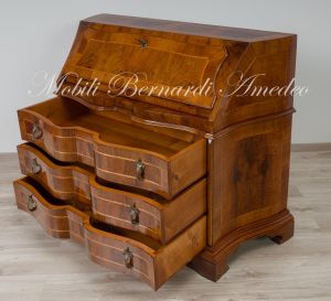 Reproduction of a baroque style chest of drawers with flap shaped in national walnut