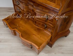 Reproduction of a baroque style chest of drawers with flap shaped in national walnut