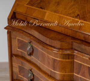 Reproduction of a baroque style chest of drawers with flap shaped in national walnut