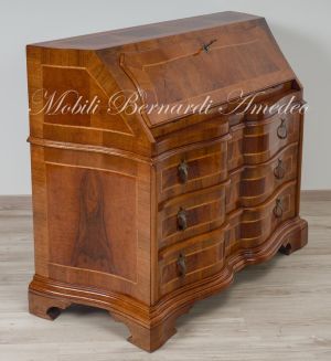 Reproduction of a baroque style chest of drawers with flap shaped in national walnut