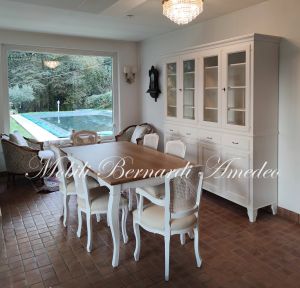 Wooden bookcase with antique white finish together with a classic living room table and chairs