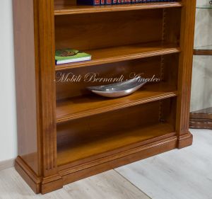 Libreria stile classico a ponte realizzata in legno di noce con capitelli intagliati e ripiani spostabili