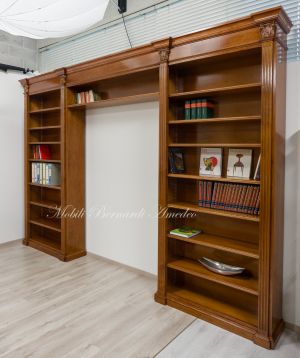 Libreria stile classico a ponte realizzata in legno di noce con capitelli intagliati e ripiani spostabili