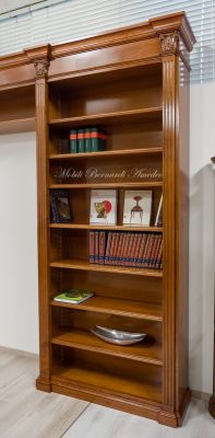 Libreria stile classico a ponte realizzata in legno di noce con capitelli intagliati e ripiani spostabili