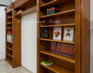 Libreria stile classico a ponte realizzata in legno di noce con capitelli intagliati e ripiani spostabili