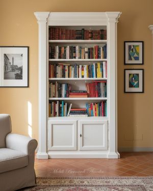 Libreria in legno finitura bianco anticato collocata in una casa classica - elaborazione grafica