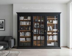 Vetrina libreria inserita in un soggiorno moderno realizzata in legno con 3 ante scorrevoli con vetro