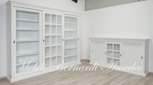 Credenza e libreria nello stesso stile con ante scorrevoli in legno e vetro finitura colore bianco