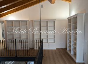 Librerie colore bianco produzione artigiale inserite in una casa moderna con pavimento e tetto in legno