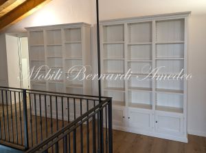 Librerie colore bianco produzione artigiale inserite in una casa moderna con pavimento e tetto in legno