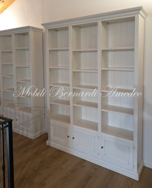 Librerie colore bianco produzione artigiale inserite in una casa moderna con pavimento e tetto in legno