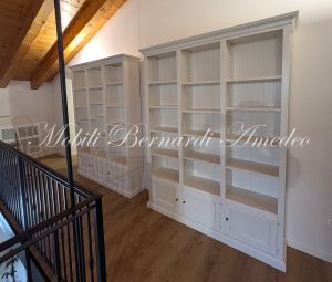 Librerie colore bianco produzione artigiale inserite in una casa moderna con pavimento e tetto in legno