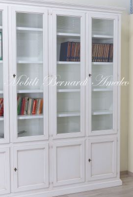 Grande libreria classica con ante a vetro realizzata artigianalmente in legno massello con finitura colore bianco anticato