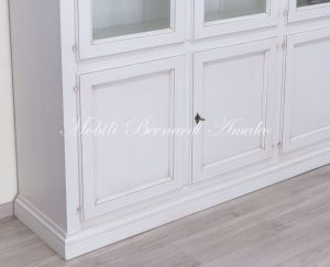 Grande libreria classica con ante a vetro realizzata artigianalmente in legno massello con finitura colore bianco anticato