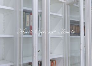 Grande libreria classica con ante a vetro realizzata artigianalmente in legno massello con finitura colore bianco anticato