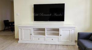 Classic style wooden TV cabinet with antique white finish inserted in a modern home
