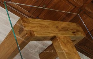 Tavolo con gambe in legno massello di ulivo e top in vetro