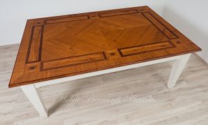 Tavolo in stile classico realizzato in legno massello e intarsiato in ciliegio ulivo e noce con gambe laccate colore bianco