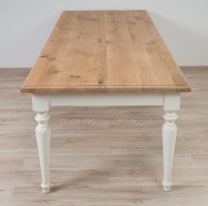 Country style wooden table with top in planed solid oak with knots and antique white turned legs