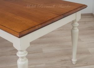 Tavolo massiccio stile country con piano in noce nazionale e gambe tornite colore bianco anticato