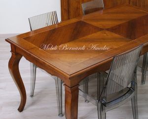 Wooden table with curved legs and barbed top