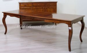 Wooden table with curved legs and barbed top