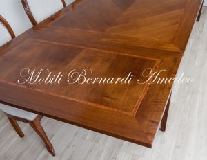 Tavolo stile classico realizzato in legno di noce con allunghe sottopiano estraibili a tiro