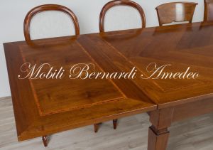 Tavolo stile classico realizzato in legno di noce con allunghe sottopiano estraibili a tiro