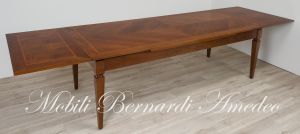 Tavolo stile classico realizzato in legno di noce con allunghe sottopiano estraibili a tiro