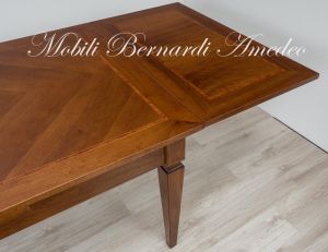 Tavolo stile classico realizzato in legno di noce con allunghe sottopiano estraibili a tiro