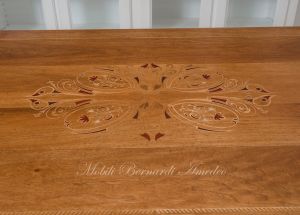 Tavolo con piano in legno di noce intarsiato colore chiaro anticato