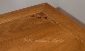 Tavolo con piano in legno di noce intarsiato colore chiaro anticato