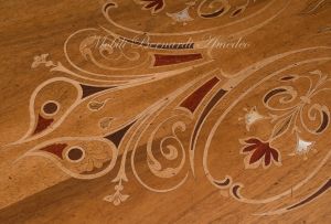 Tavolo con piano in legno di noce intarsiato colore chiaro anticato