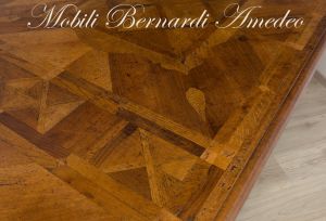 Tavolo di grandi dimensioni realizzato in legno massiccio con intarsi stile classico produzione artigianale italiana