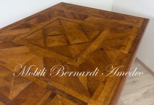 Tavolo di grandi dimensioni realizzato in legno massiccio con intarsi stile classico produzione artigianale italiana