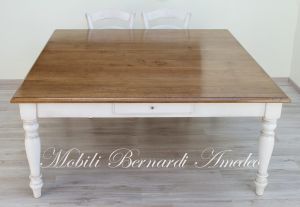 Tavolo quadrato di grandi dimensioni realizzato in legno massello finitura tipo country-provenzale con gambe tornite bianche e piano in rovere
