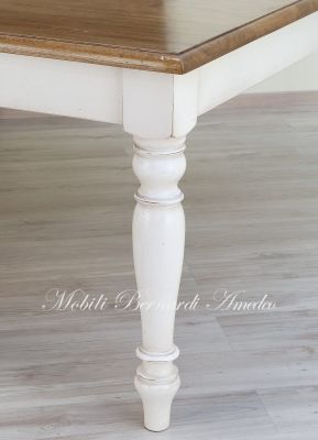 Tavolo quadrato di grandi dimensioni realizzato in legno massello finitura tipo country-provenzale con gambe tornite bianche e piano in rovere