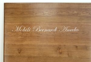 Tavolo quadrato di grandi dimensioni realizzato in legno massello finitura tipo country-provenzale con gambe tornite bianche e piano in rovere