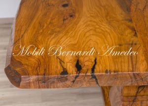 Tavolo realizzato in legno massello di ulivo con piano formato da due assi intere con bordi lasciati irregolari al naturale