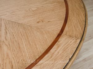 Tavolo rotondo con piano in rovere chiaro piallato anticato e intarsio in legno scuro