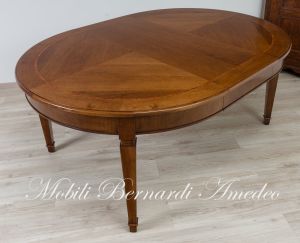 Tavolo rotondo classico realizzato in legno di noce con prolunghe aggiuntive e gambe stile Luigi XVI